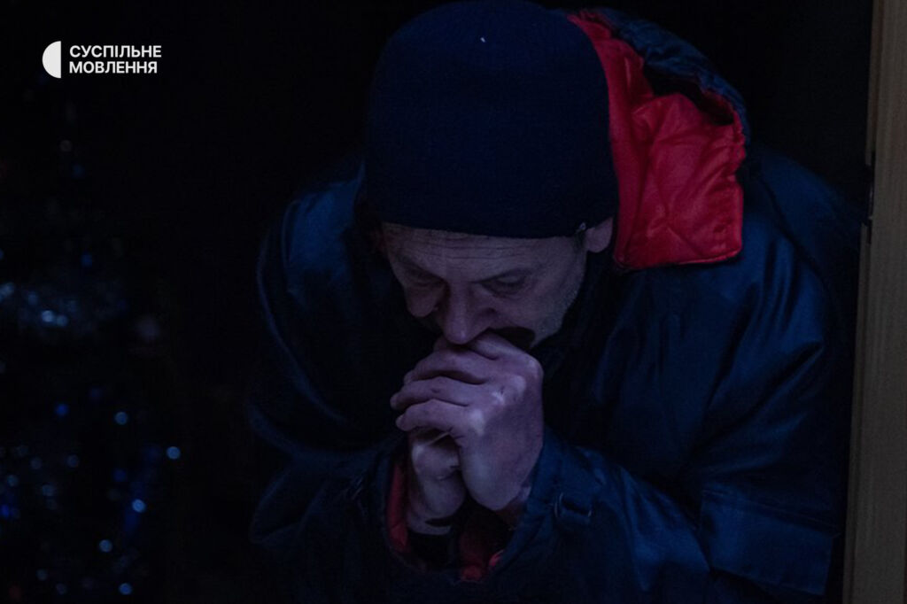 Чоловік сидить, спершись на руки